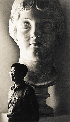 japanese tourist posing next to roman head, tunisia